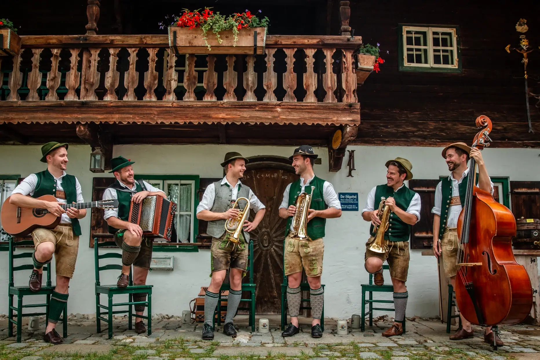 Die Musiker der Tanzlmusi Duanix spielen vor einem alten Bauerhaus zünftig auf.