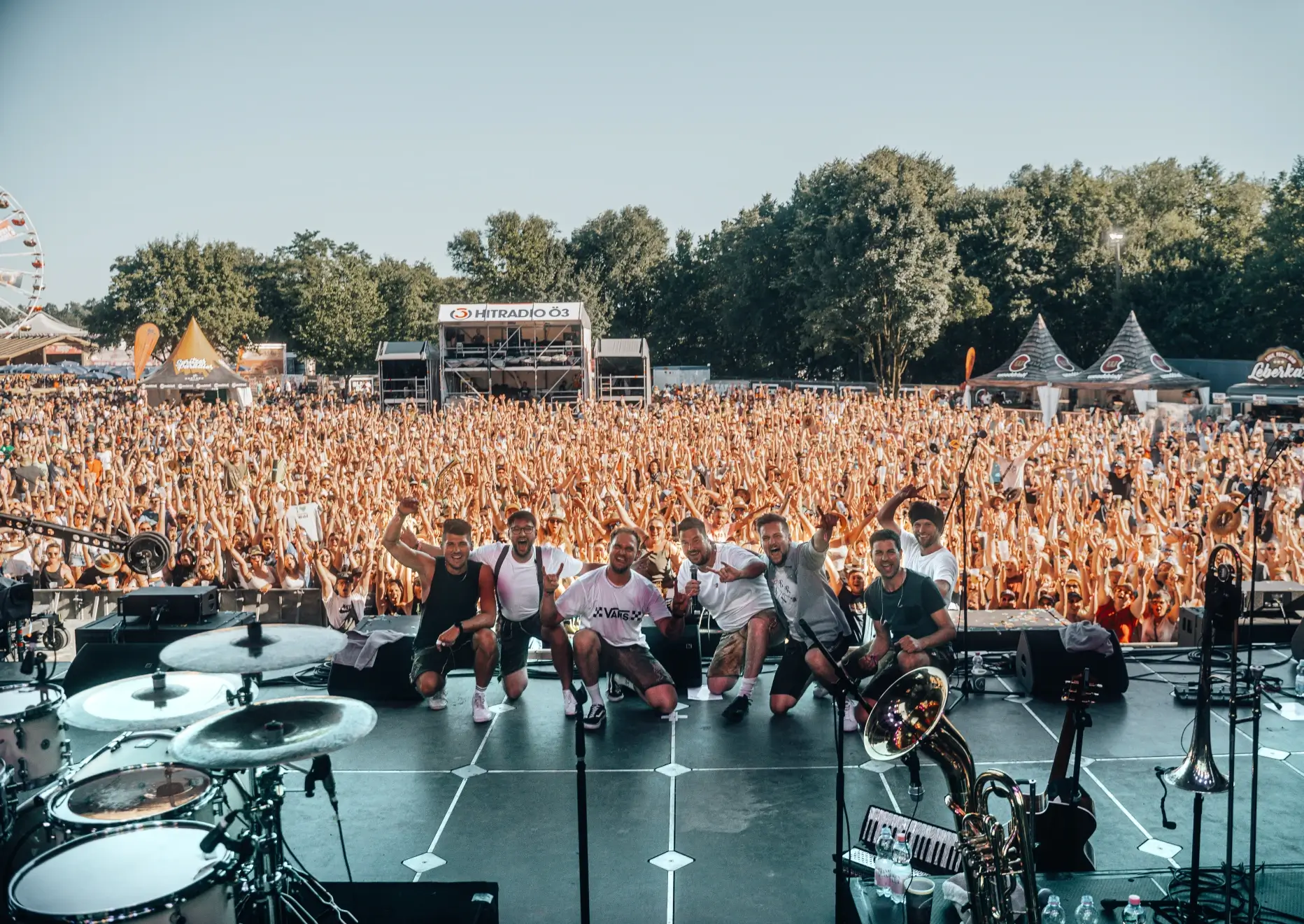Die Bayrische Partyband Hundskrippln auf der Bühne vor dem jubelnden Publikum bei einem Festival in Bayern.