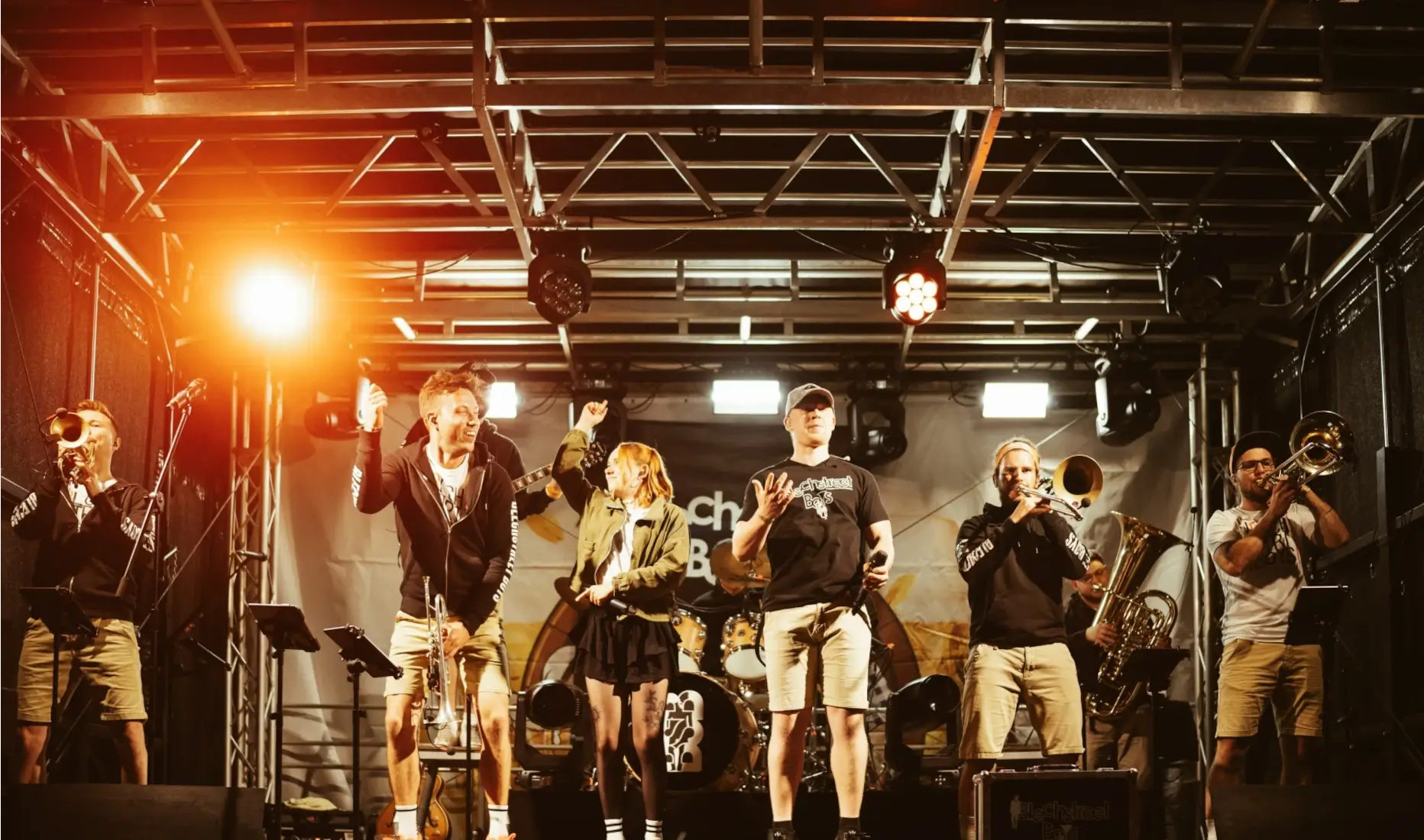 Die Musiker der Blechstreet Boys mit ihren Instrumenten auf der Bühne nebeneinander.