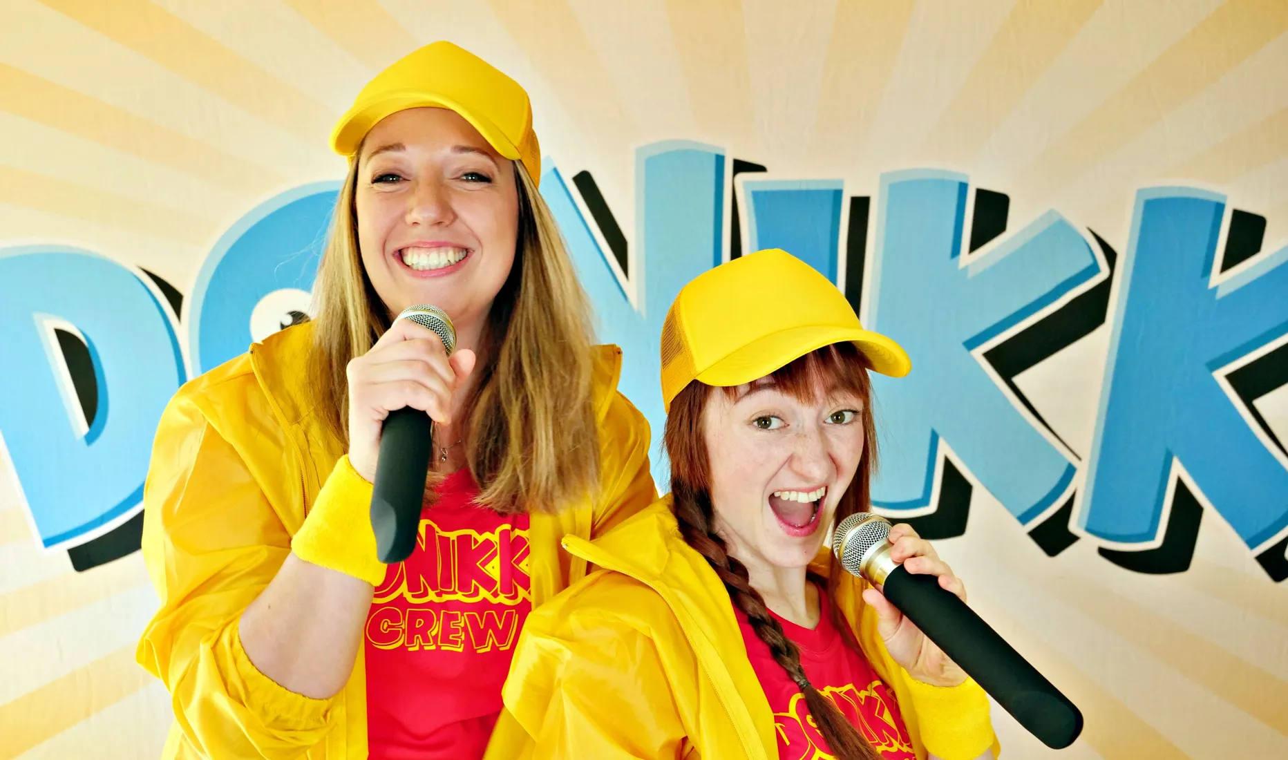 Donikkl Crew – die Kinder- und Jugendband aus Bayern live auf der Bühne mit gelben Outfits und Mikrofonen, energiegeladene Performance für junge Fans.
