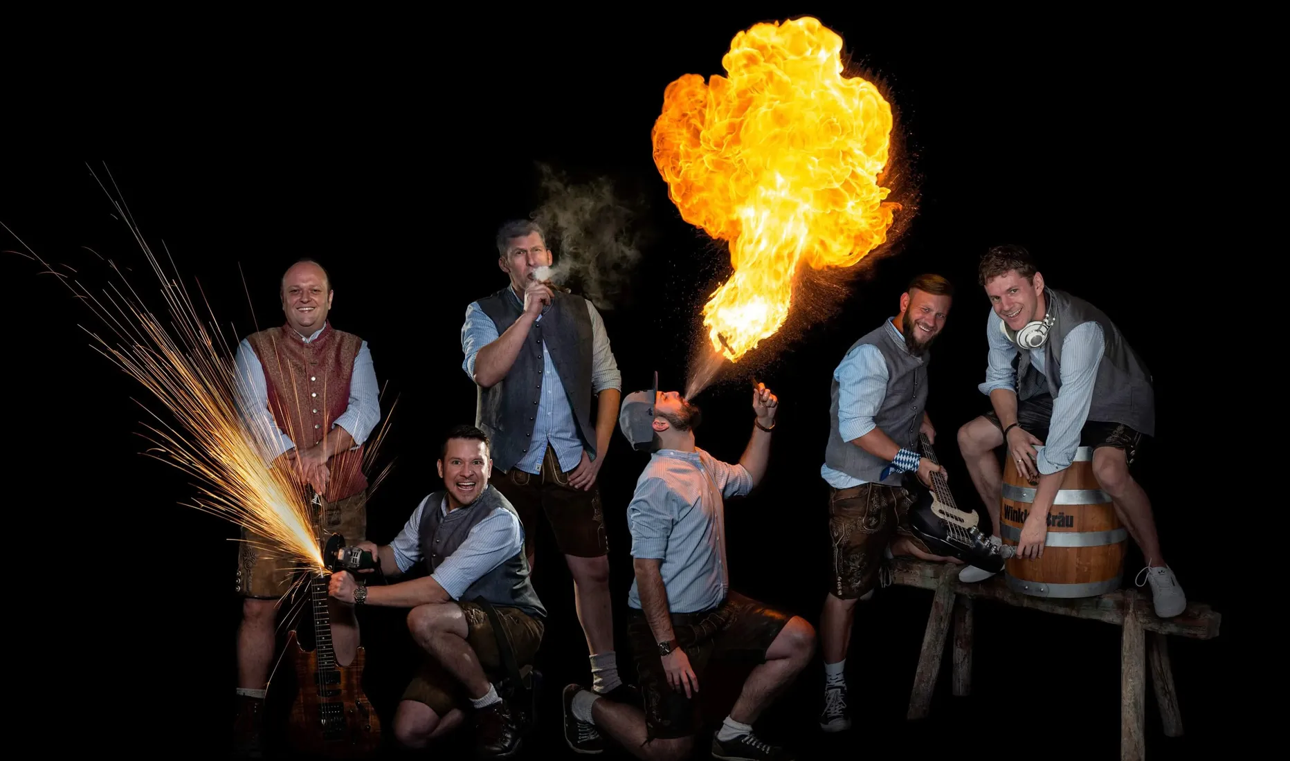 Donnaweda – die bayrische Partyband aus Hemau mit spektakulärer Showeinlage, Musiker in Lederhosen mit Feuer spucken, Funken sprühen und Instrumenten vor schwarzem Hintergrund.