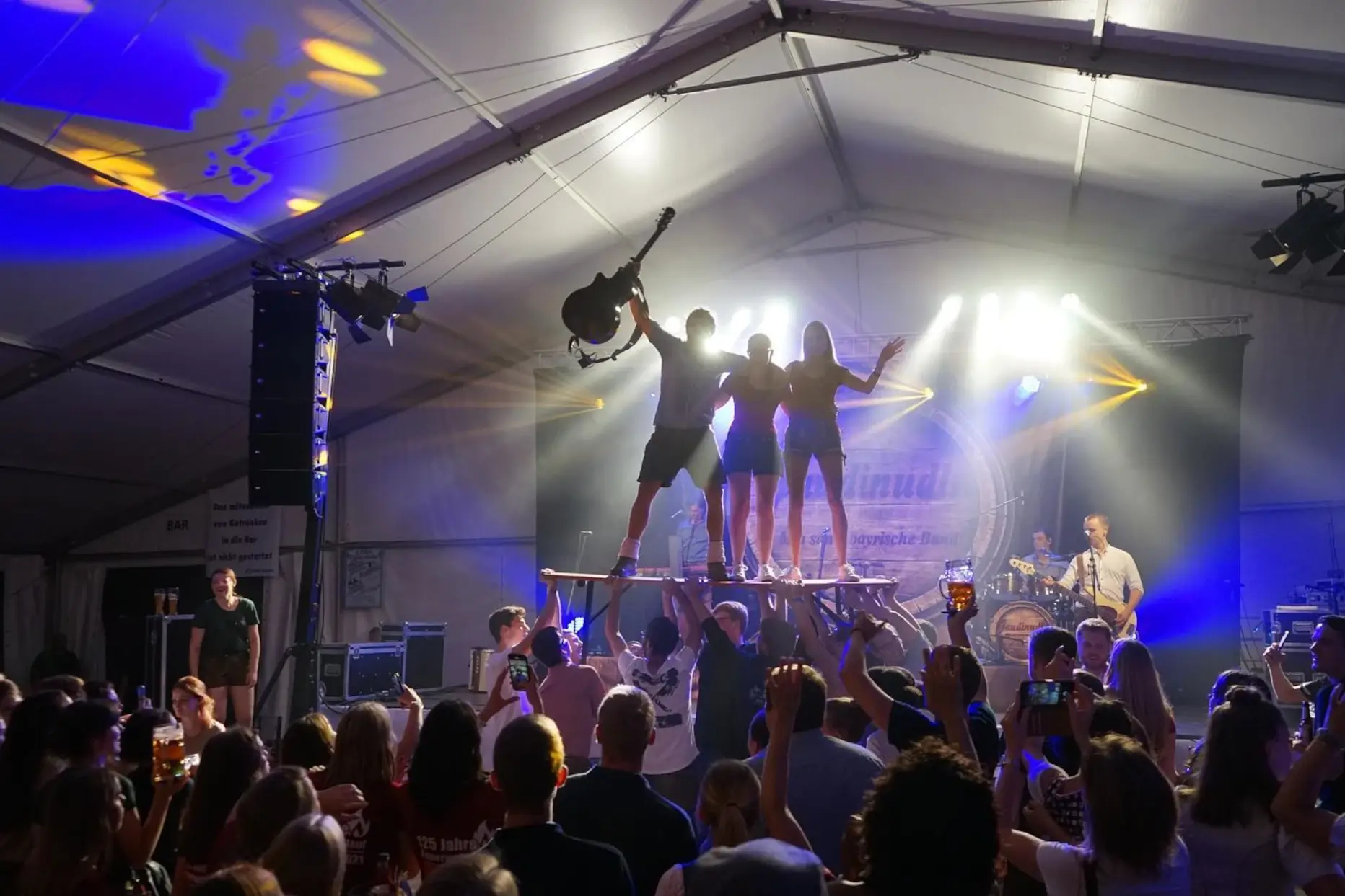 Gaudinudln – die bayrische Partyband aus Sengenthal live im Festzelt, ausgelassene Stimmung mit Tänzern auf Bierbänken, Lichteffekten und feierndem Publikum – ideal für Volksfest, Gründungsfest oder FF-Jubiläum.