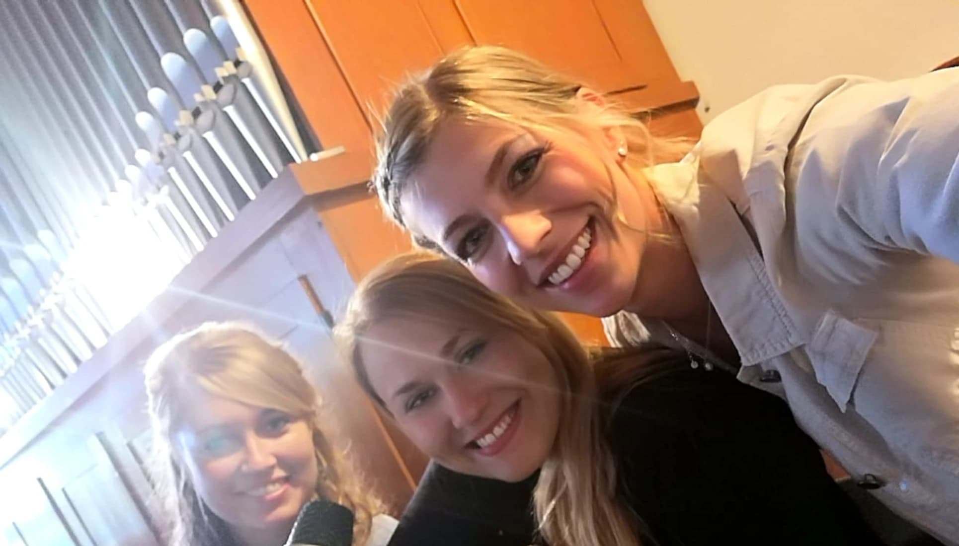 Die drei Musikerinnen der Band Saitenwind bei einem Selfie auf der Empore in einer Kirche bei einer Hochzeit.