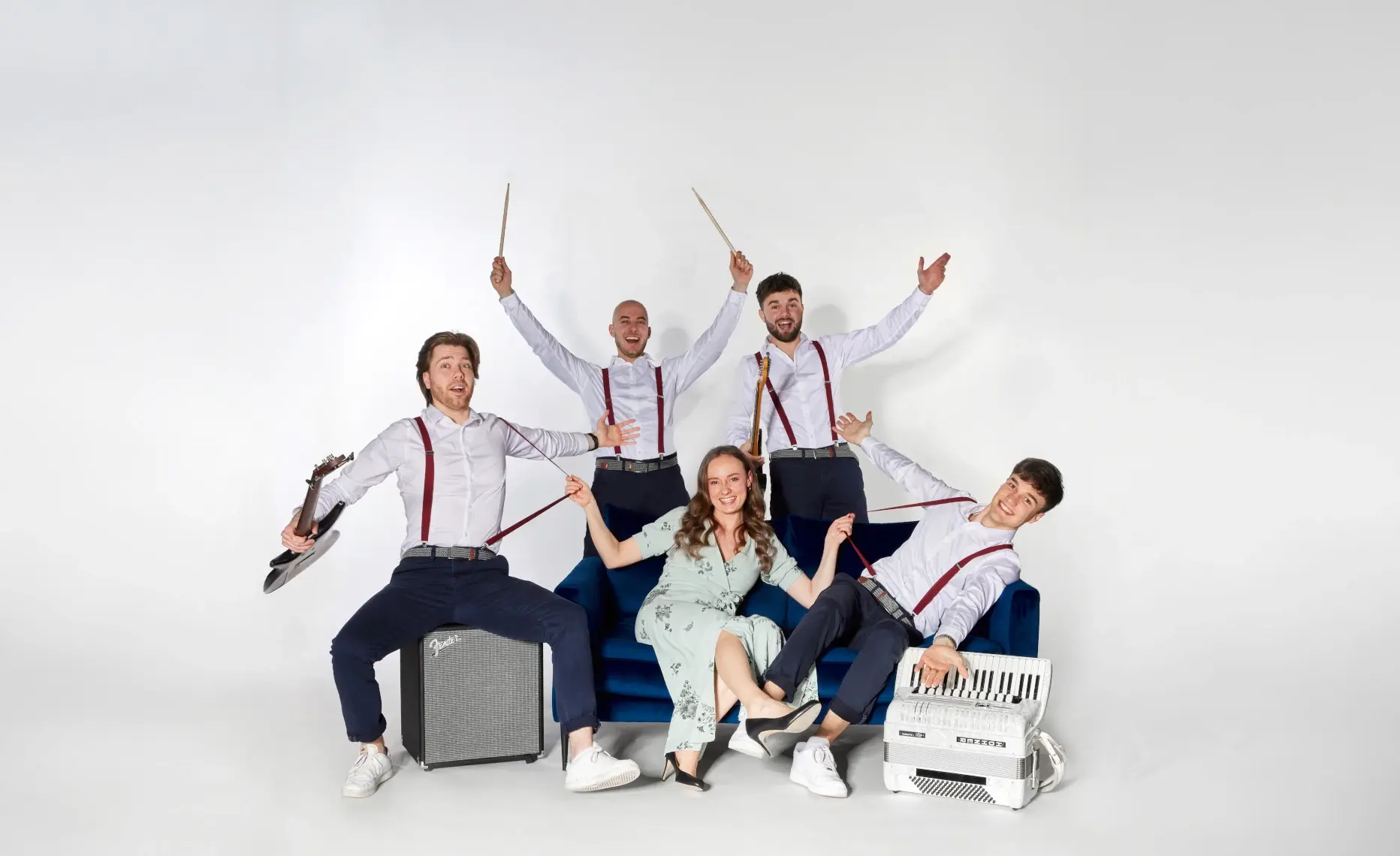 Bandfoto von MIXTAPE aus Niederbayern im Studio auf blauem Sofa, mit Gitarre und Akkordeon.