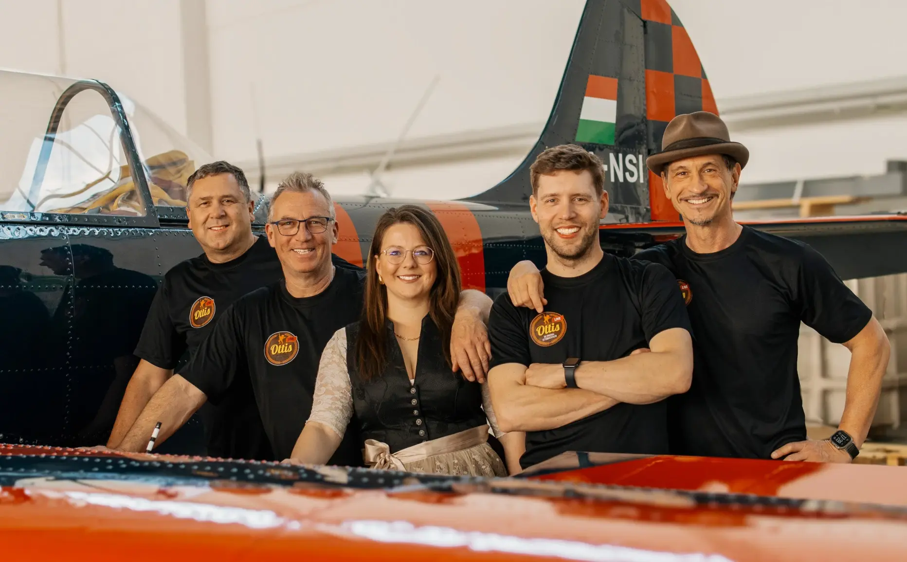 Die Partyband Ottis im einen rustikalen Stodl sitzend auf einem alten Pferdeanhänger.