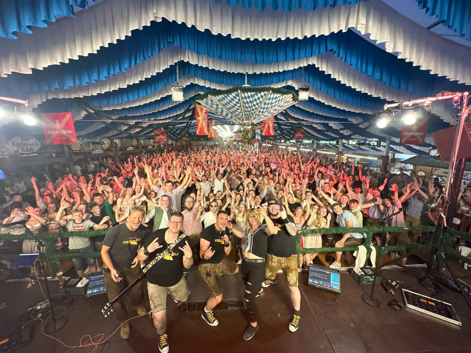 Bayerische Partyband „zruck zu dir!“ live im Festzelt vor feierndem Publikum auf einem Volksfest.